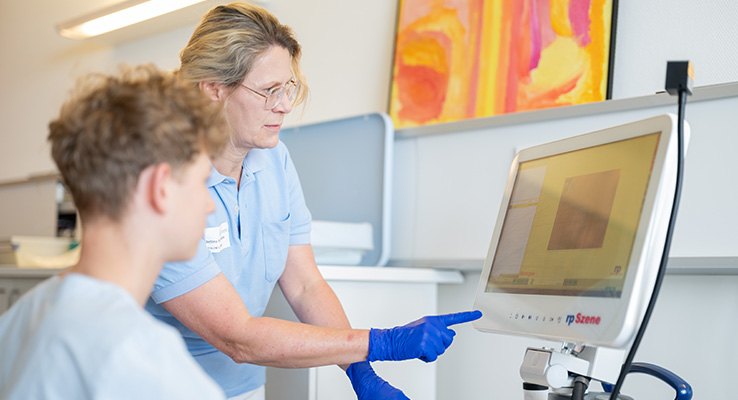 Logopädin erklärt einem Praktikanten die Auswertung einer computergestützten Schluckdiagnostik.
