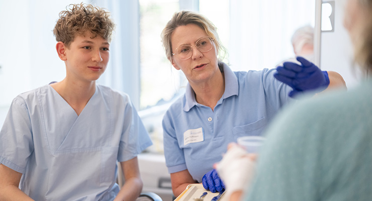 Praktikant begleitet eine Logopädin bei einer Therapie mit einer Patientin.